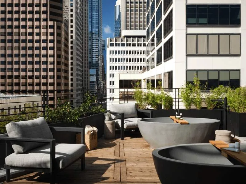 Outdoor stone soaking tubs on the rooftop wellness terrace at 1 Hotel San Francisco.