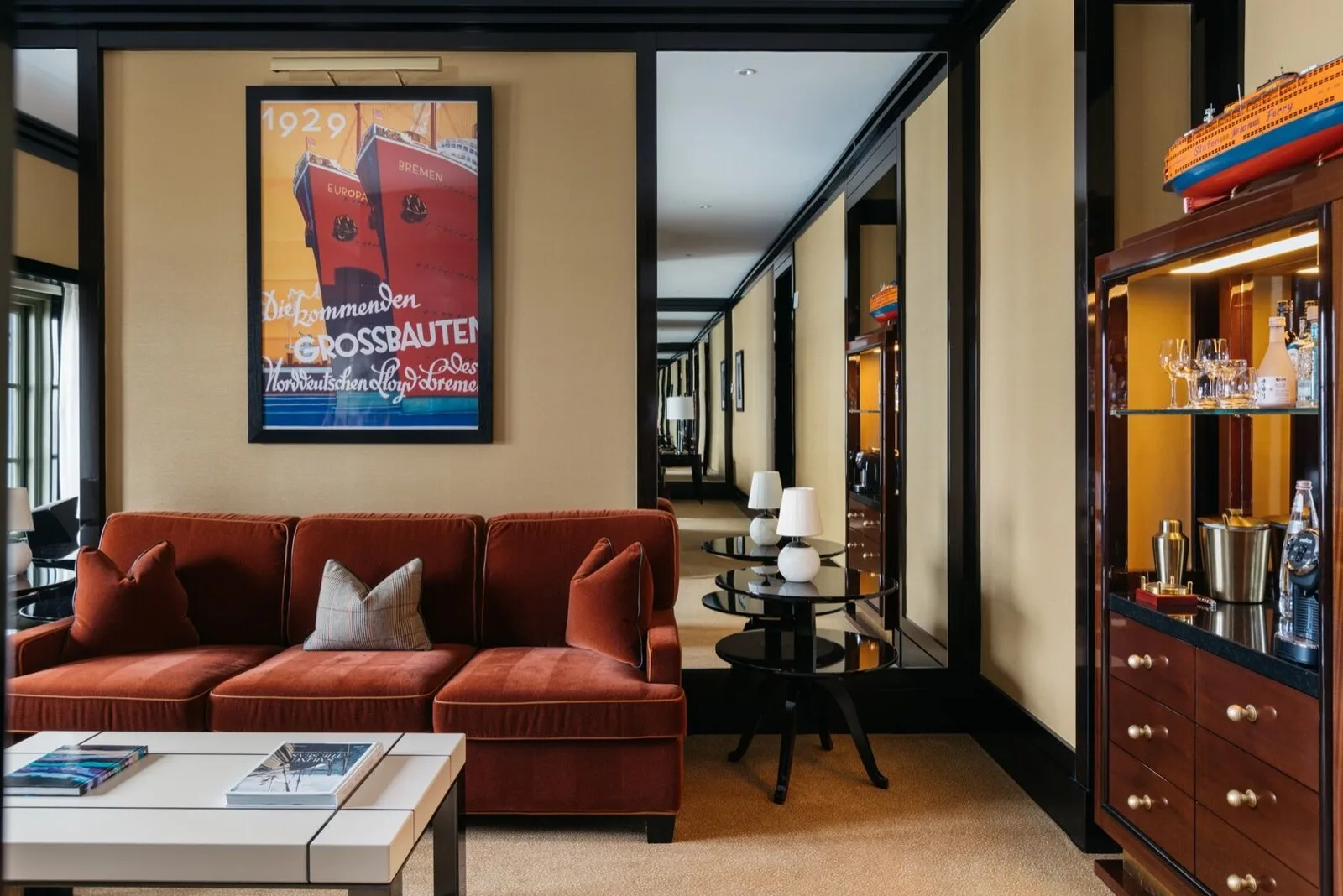 Casa Cipriani New York lounge with a rust-colored sofa and maritime artwork