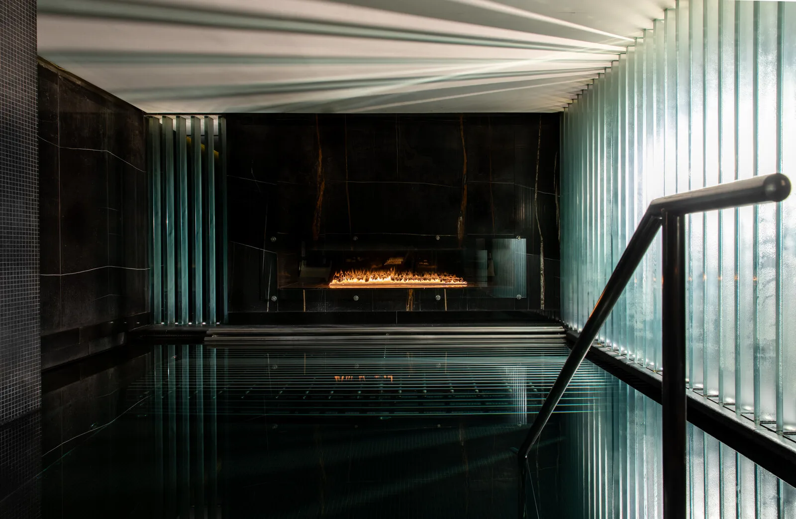 Dark tiled vitality pool inside Biome at Corinthia London.