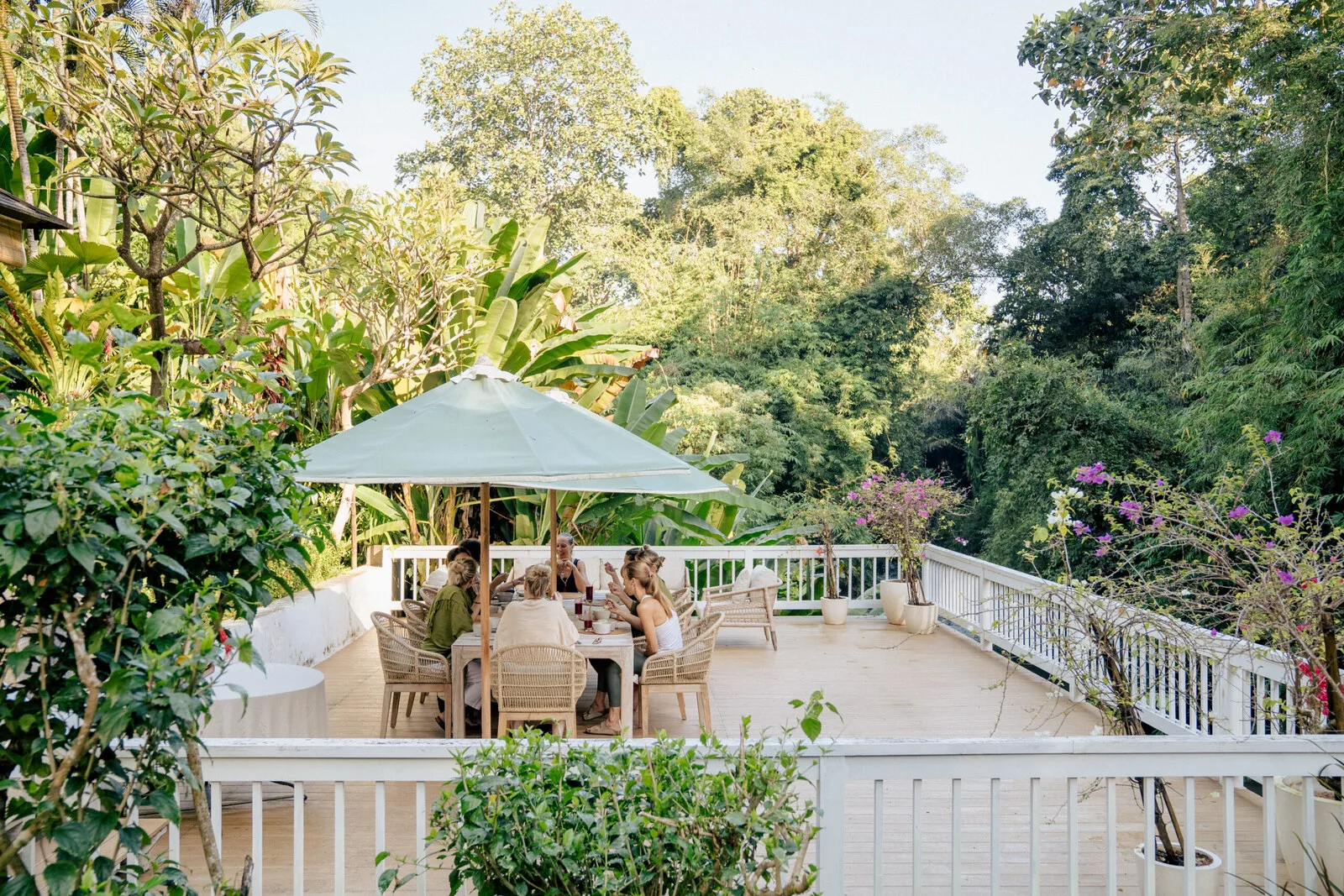Guests dining on a terrace surrounded by tropical greenery